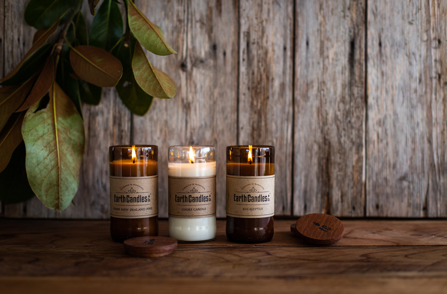 200g Earth Candles made from upcycled beer bottles, burning with a warm, inviting glow.